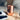 Sojourn Nourish Your Soul” Candle Mood Image - Copper‑plated Sojourn candle placed on a light wooden surface beside a monochrome magazine cover, set within a soft, cozy living‑room scene that evokes calm, warmth, and soulful nourishment.