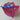 Sojourn burgundy crochet handbag with two handles, a matching tassel, a rose quartz teardrop shape natural gemstone, and a vibrant pink, turquoise, and red patterned fabric dust bag,  photographed on a neatral surface.