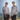 Portrait of Sojourn founders Birgit Rieder and Nancy Leach standing outdoors in a grassy field with sunlight behind them, facing the camera with gentle smiles. The background is softly blurred.