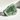 Large opaque green aventurine gemstone with natural facets resting on a white surface, highlighting its deep green hue.